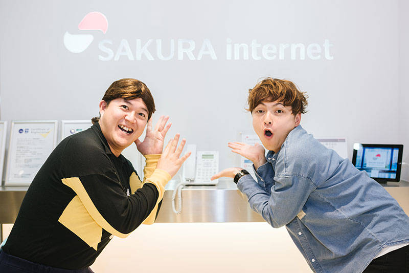 さくらインターネットのロゴ前で写真を撮るしゃかりきのおふたり